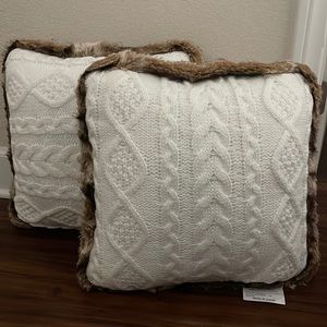 Pair of white throw pillows with faux fur around the edges